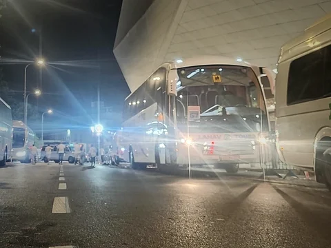 שורת אוטובוסים חונה מתחת לגג האצטדיון בלילה, אחרי אירוע