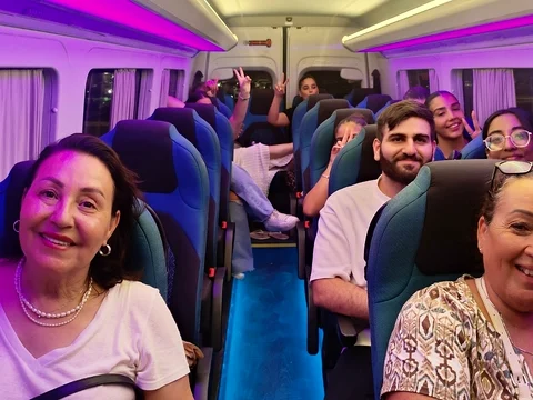 מיניבוס מלא נוסעים מחייכים בדרך חזרה מאירוע